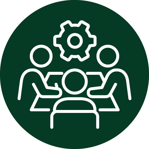 This is a graphic icon representing three stylized figures around a table with a gear above, symbolizing collaboration, teamwork, or a meeting focused on problem-solving or engineering.