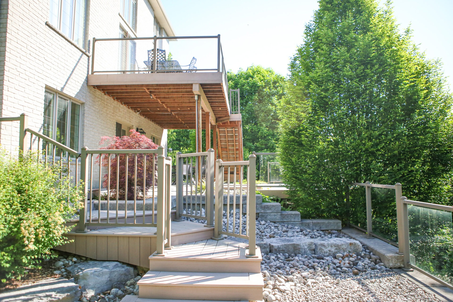 Steps leading to a backyard with an elevated patio above it.